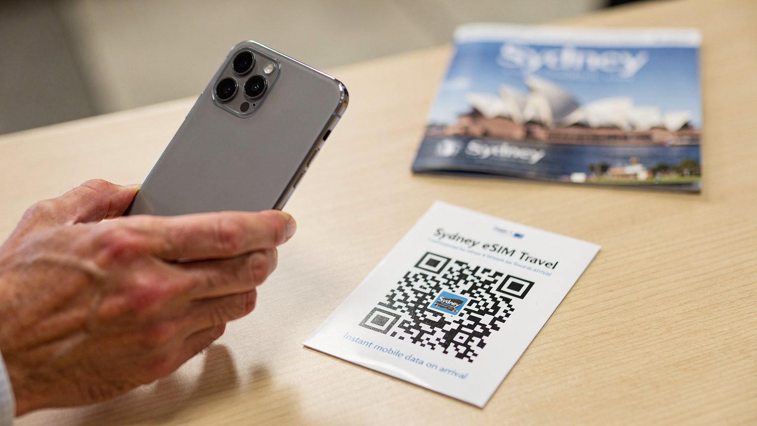 Un primo piano di un codice QR di eSIM stampato su una brochure di viaggio, pronto per essere scansionato da un telefono.